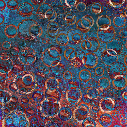 Multi-colored rings and their reflections are located on a red-blue background. Abstract abstraction