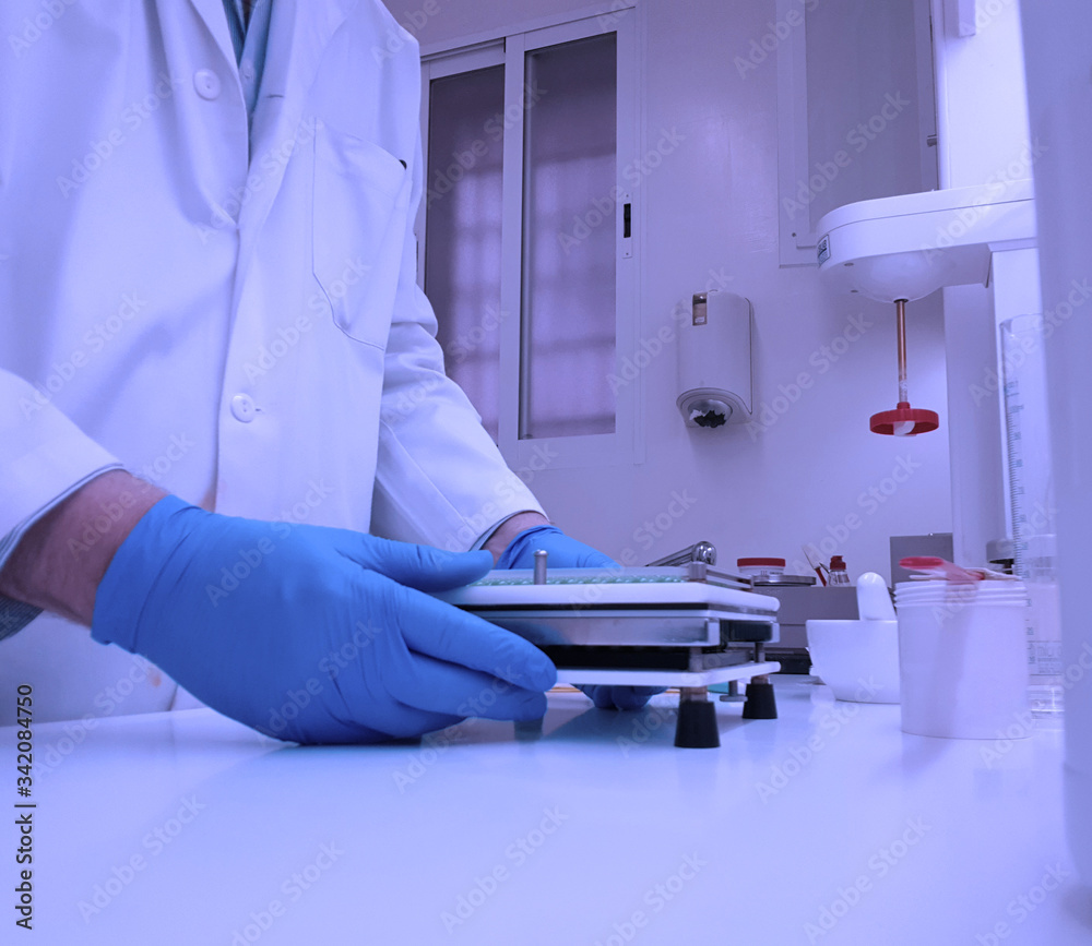 Pharmacist preparing capsules in a pharmacy laboratory Pharmacist preparing capsules in a pharmacy laboratory
