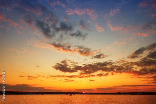 Beautiful sunset on the lake with clouds and reflections on the water