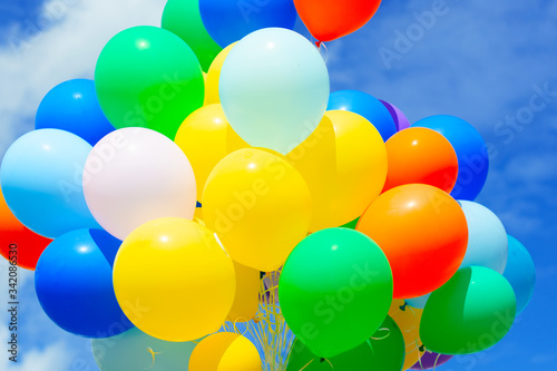 Bright multicolored festive balloons against a blue sky.