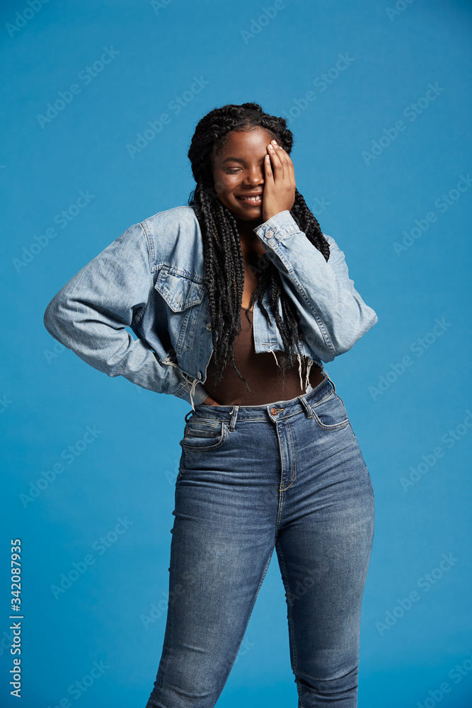 Positive beautiful African American woman with braids in denim outfit ...