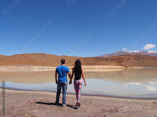 Couple hand by hand watching on laguna, mountains and salt lake, Altiplano, Bolivia. Copy space for text