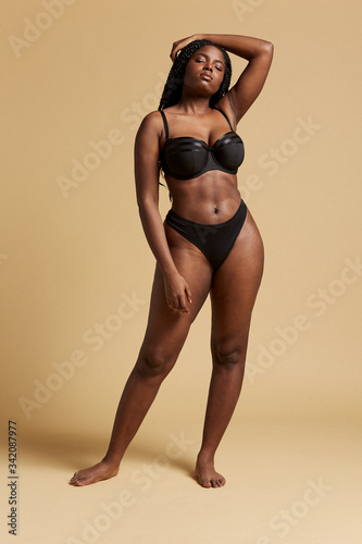 Curvy beautiful African American woman with braids in lingerie with closed  eyes against yellow background Photos | Adobe Stock