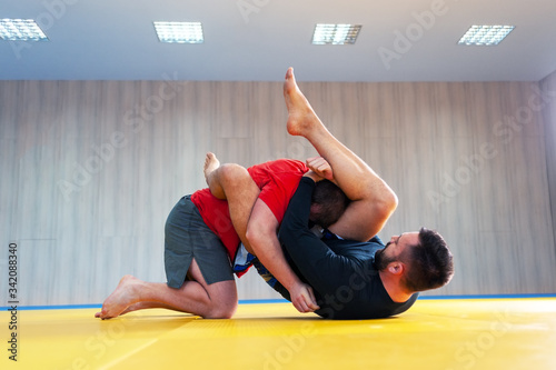 Grappler trying to choke his opponent in ground fight photo