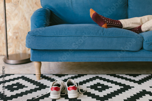 Crop businesswoman with shoes off chilling on blue soft couch during workday enjoying break photo