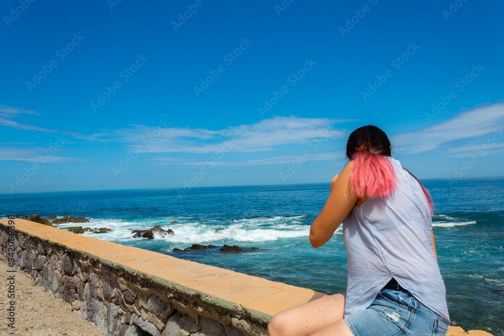 Young Hispanic woman with pink hair enjoying a Mazatlan beach vacation