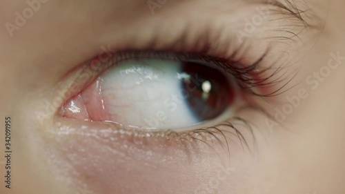Extreme close-up of a girl's brown eye with long lashes looking up, down and to the sides.