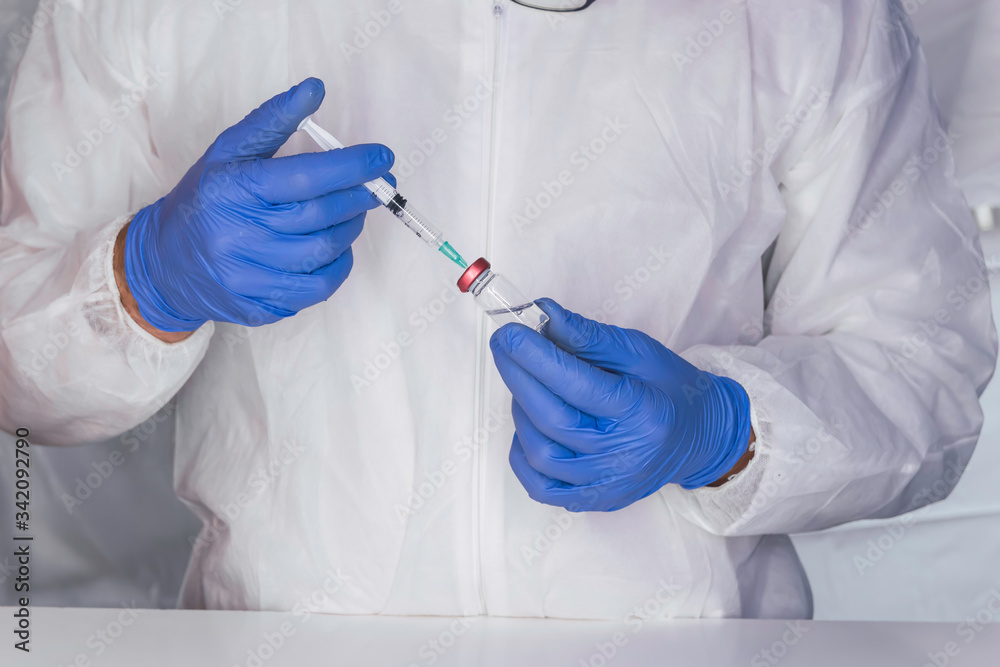 Health cure concept hand with blue medical gloves and new vaccine. Covid virus 19, vaccine vial Health cure concept hand with blue medical gloves and new vaccine. Covid virus 19, vaccine vial