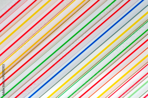 Multi-colored cocktail tubes lie diagonally for an abstract bright background