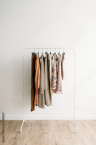 Rack with capsule clothes in beige colors