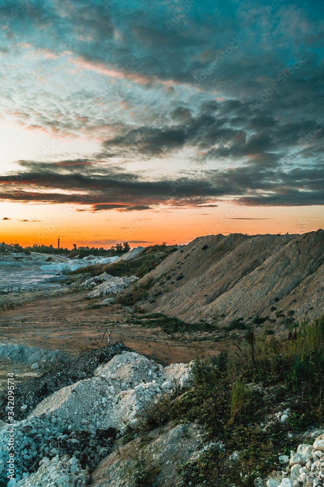 Industrial landscape with sunset sky over kaolin mining site in Hlukhivtsi, Ukraine