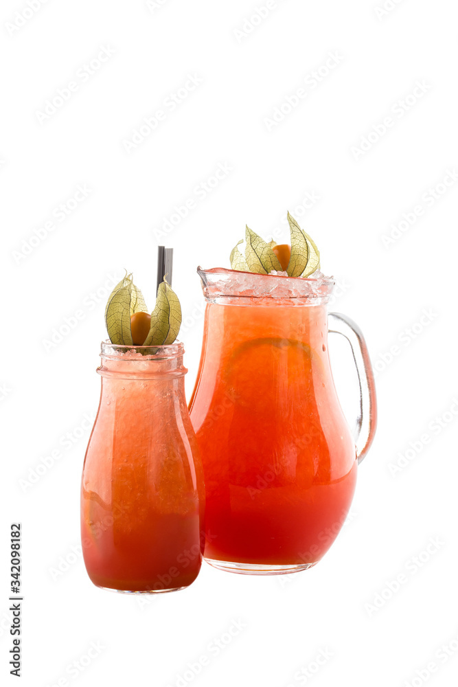 Orange and lime lemonade in pitcher and glass isolated on white background Orange and lime lemonade in pitcher and glass isolated on white background