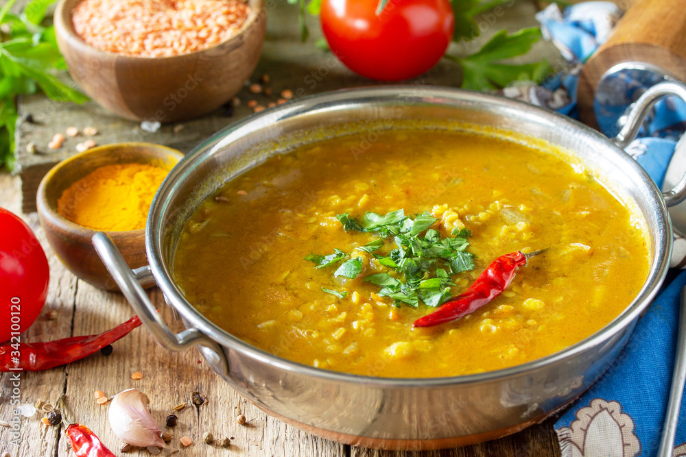 Indian food, a real Indian dish. Traditional Indian spicy lentil puree soup with herbs on a rustic table. Indian food, a real Indian dish. Traditional Indian spicy lentil puree soup with herbs on a rustic table.