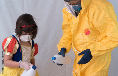 man in yellow biological protection suit disinfects another's hands and both wear safety gloves and safety masks