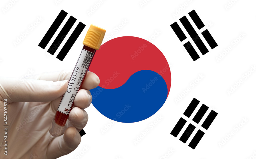 COVID-19 Pandemic Coronavirus concept ; Close-up of a Positive COVID-19 blood test sample tube with Flag of South Korea at background. Blood testing for diagnosis new Corona virus infection. COVID-19 Pandemic Coronavirus concept ; Close-up of a Positive COVID-19 blood test sample tube with Flag of South Korea at background. Blood testing for diagnosis new Corona virus infection.