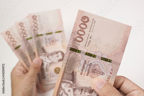 Obraz na plátně Close up Hands Counting Money in Thai Banknote, 4 Thousand baht on white backgro