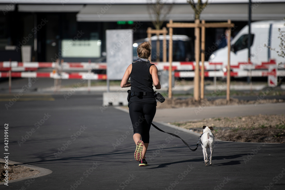 Running woman with her white dog.