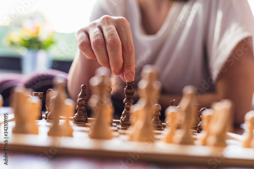Pensive woman plays chess