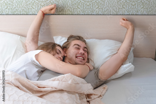 beautiful married couple lies hugging in bed, life together, relationship in a pair