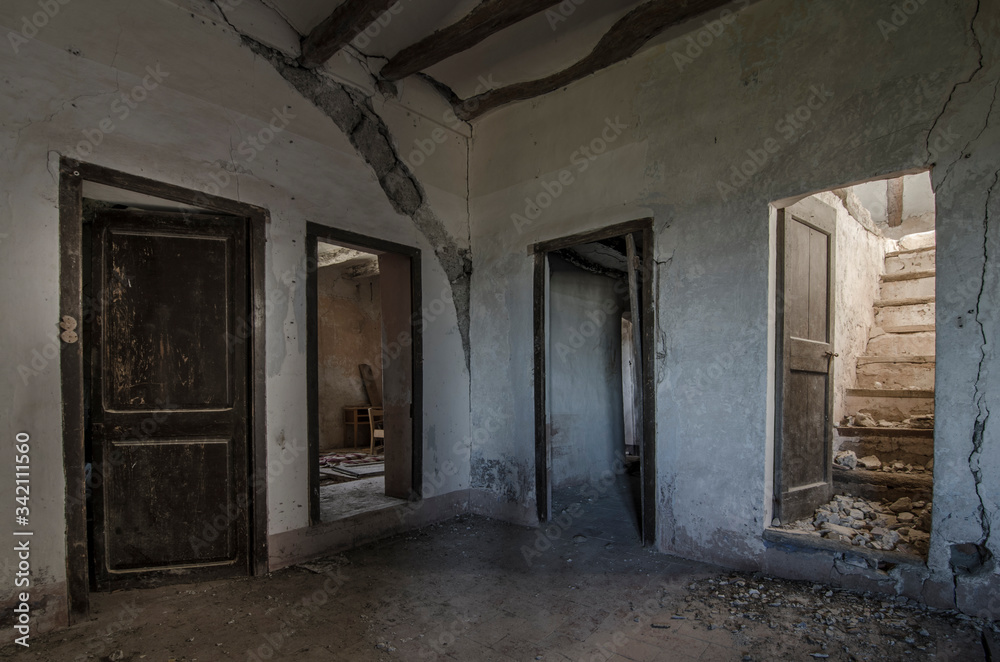 Fototapeta premium Habitación sucia con puertas en la penumbra de casa de campo abandonada en ruinas. 