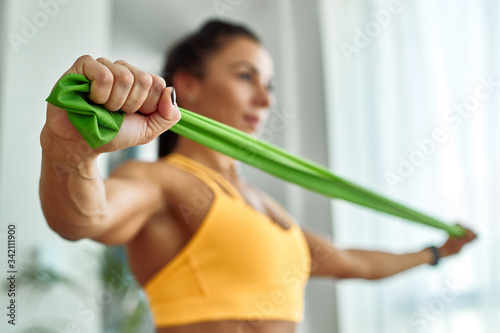 Obraz na płótnie Close-up of athletic woman exercising with resistance band at home