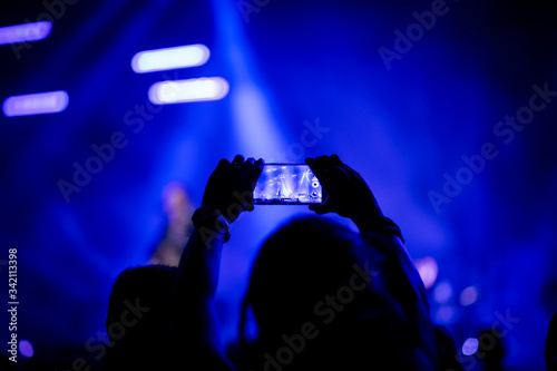 mujer grabando un concierto de música con su móvil