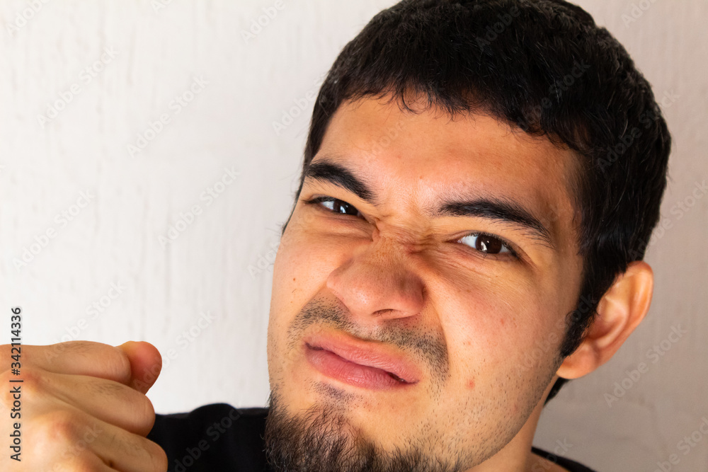 portrait of a young Hispanic man threatening with his fist portrait of a young Hispanic man threatening with his fist