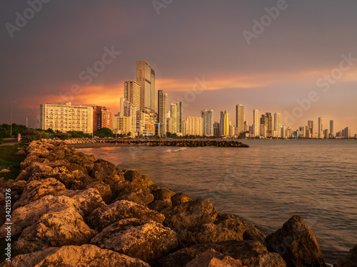 Sunset over a coastal city with skyscrapers along the coastline 