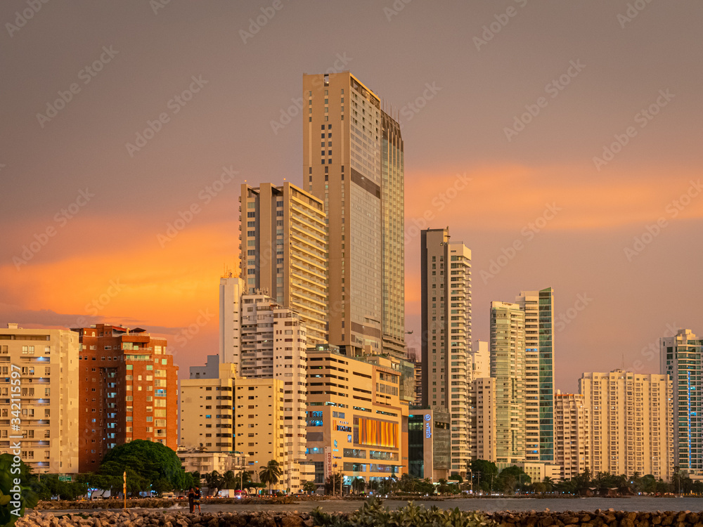 Sunset over a coastal city with skyscrapers along the coastline 