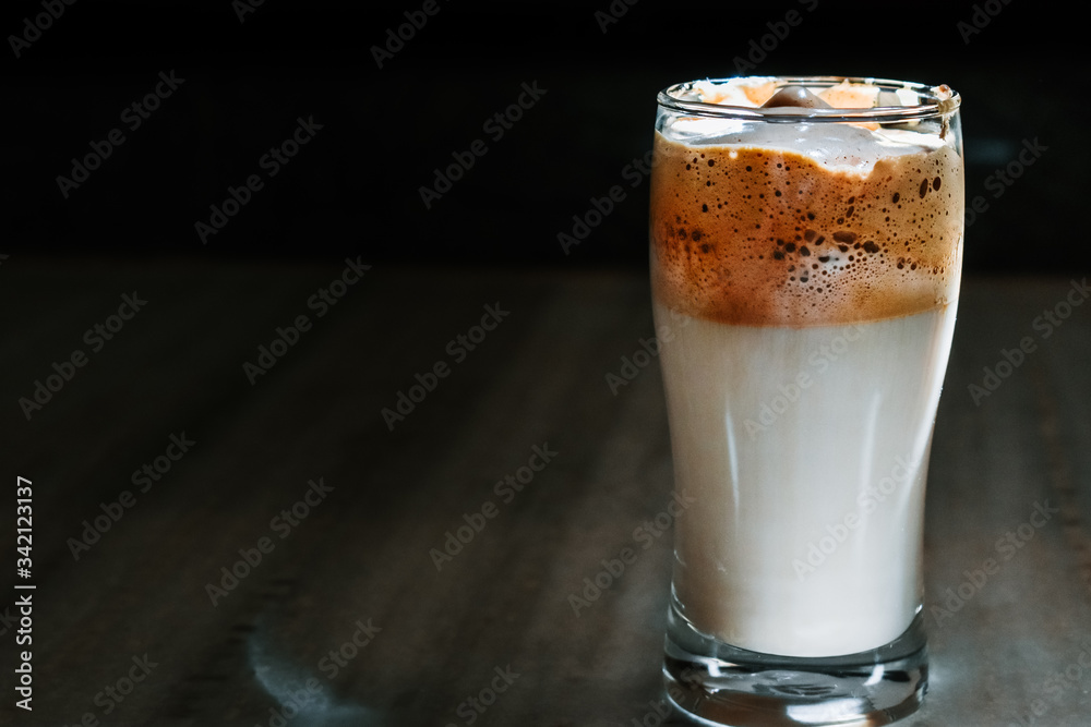 Closeup shot of Dalgona coffee in glass on a table Closeup shot of Dalgona coffee in glass on a table