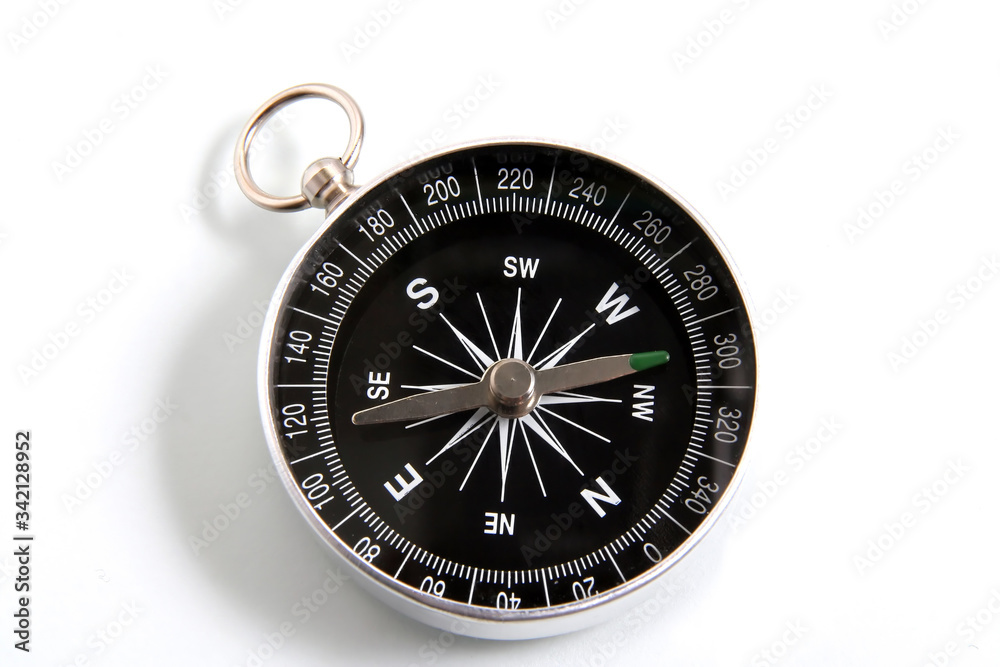 Closeup compass isolated on a white background. Travel geography navigation modern compass Closeup compass isolated on a white background. Travel geography navigation modern compass