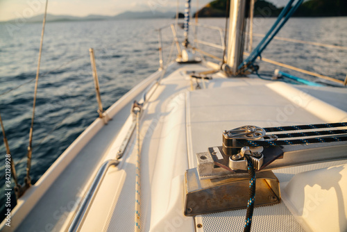 The bow of a large sailing yacht with a latch for fans. against the backdrop of the sea, islands and sky.