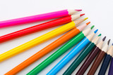 colored pencils arranged on a rainbow on a white background