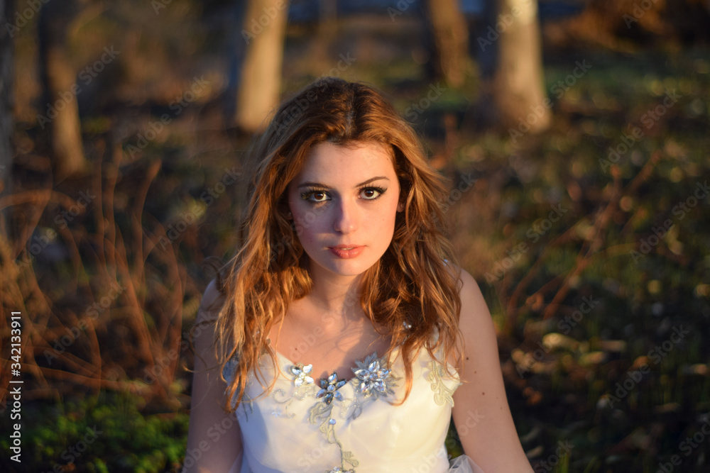 Beautiful girl with charming look with a white wedding dress in the forest Beautiful girl with charming look with a white wedding dress in the forest