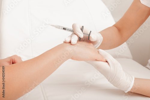 Injection of the hands. Syringe with filler for hands. Cosmetology clinic. Health care  cosmetology concept.