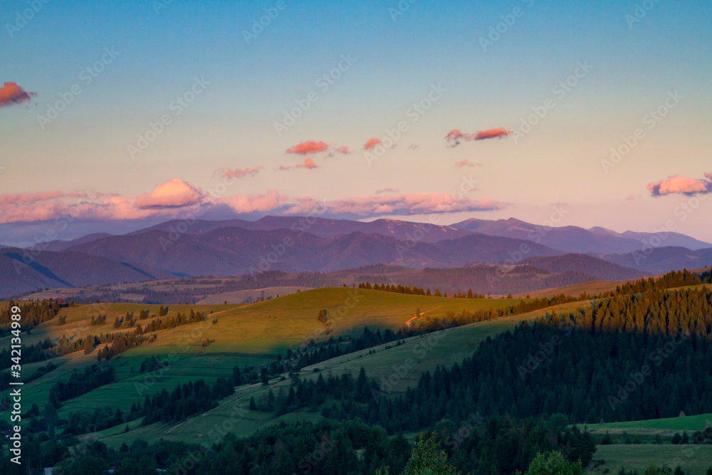 Mountain range at sunset in summer. Clouds over the mountains at sunset. Carpathian mountains