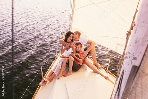 Happy family with son resting on a sailing yacht © VlaDee