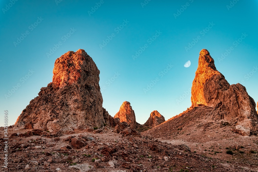The Trona Pinnacles against the first light of morning with the moon in the sky. 