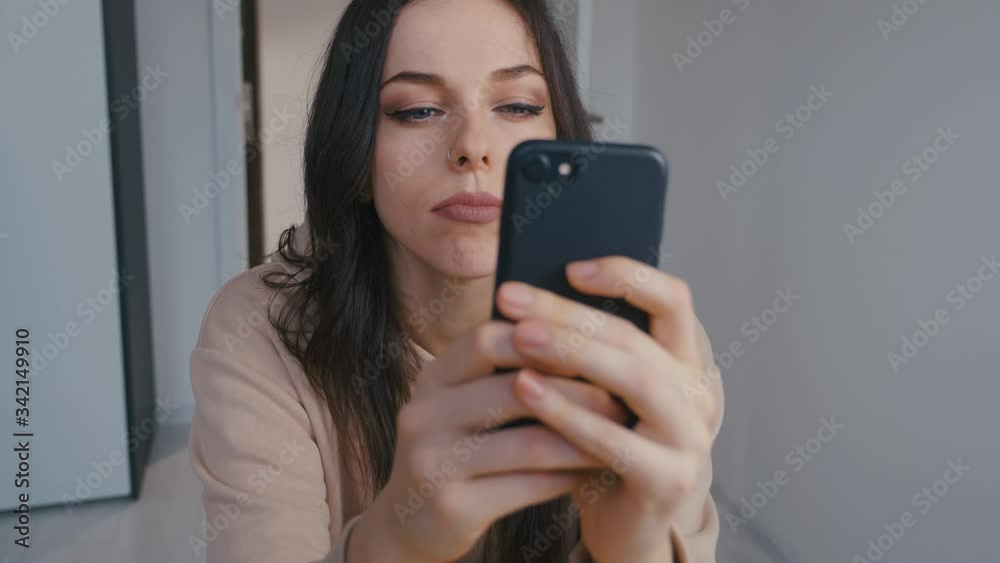 Happy young woman using smartphone and drinking coffee. Smiling millennial girl looking at mobile phone screen, typing message in social network, shopping online, web surfing. Happy young woman using smartphone and drinking coffee. Smiling millennial girl looking at mobile phone screen, typing message in social network, shopping online, web surfing.