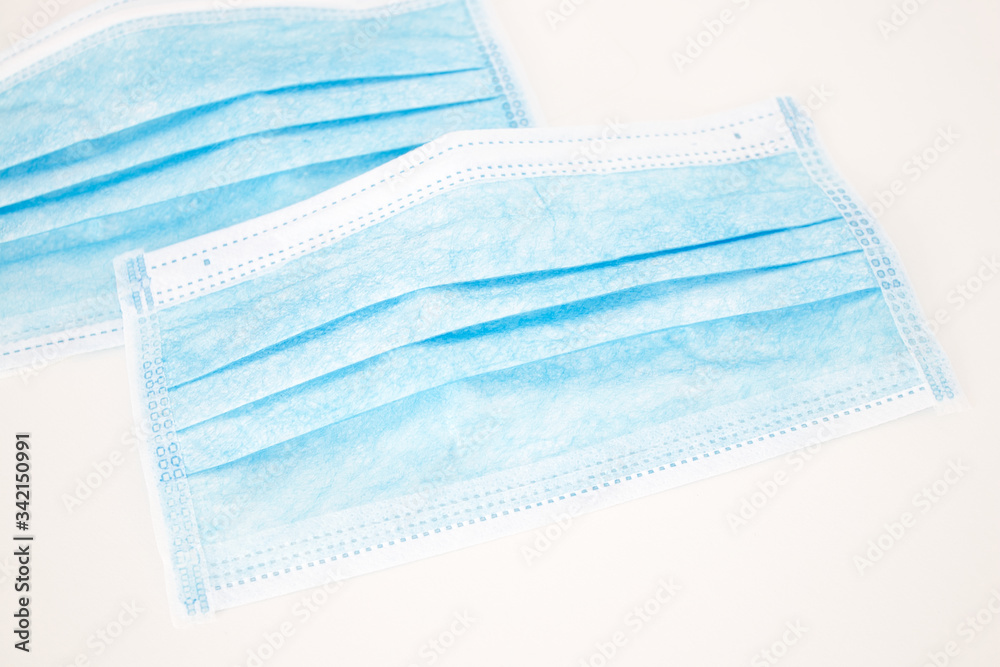 Close up of two Blue Disposable Medical Face Masks on a White Background. Coronavirus concept Close up of two Blue Disposable Medical Face Masks on a White Background. Coronavirus concept