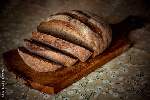 round bread, lying on a brown, wooden Board 