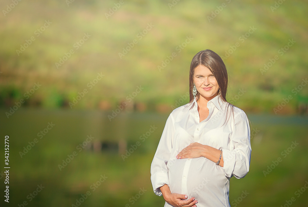 Pregnant woman in outdoor park, warm weather Pregnant woman in outdoor park, warm weather