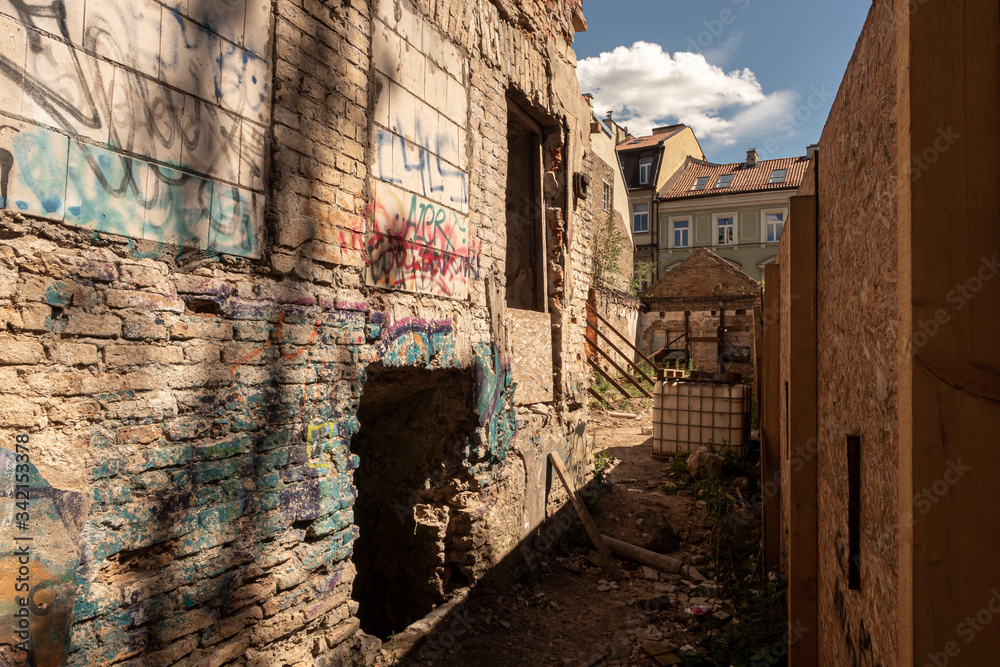 Narrow passage next to a ruined old building Narrow passage next to a ruined old building