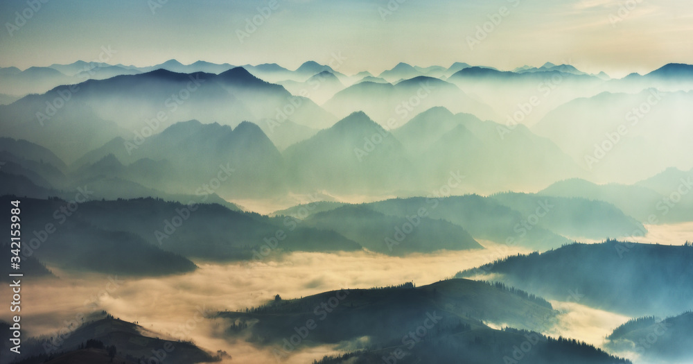 silhouettes of foggy mountains. picturesque mountain peaks at sunrise.