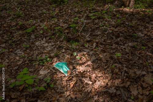 Face Mask laying on the ground in the forest. Corona virus may be on that mask.