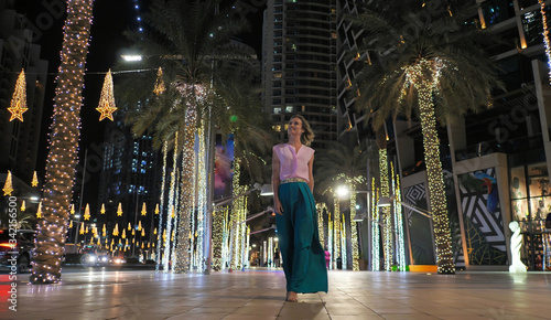Photography A young woman is walking along the evening Dubai.