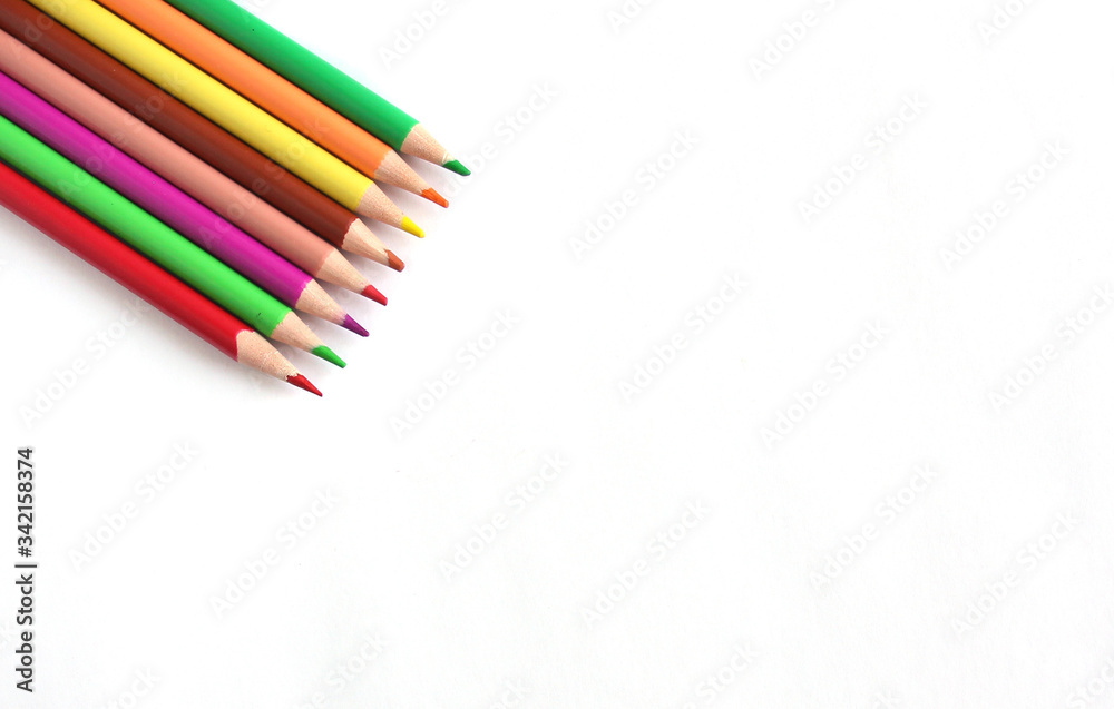 Color pencils on white background, copy space, a close up. Color pencils on white background, copy space, a close up.