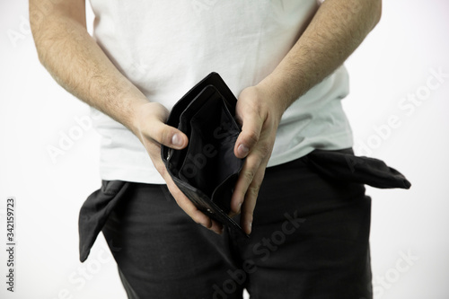 Caucasian whites men's hands show empty open dlack wallet and empty pants pockets turned inside out isolated on white background close up . concept of poverty, cash is out