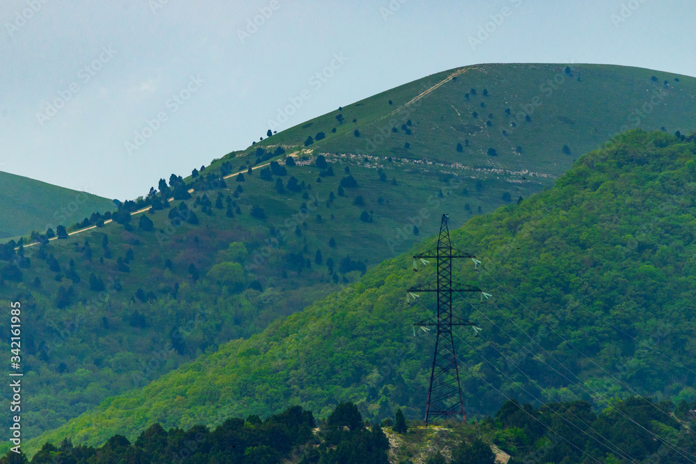Obraz premium High voltage power lines in mountain forest