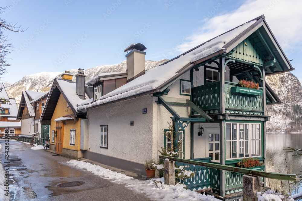 Village street by lake Hallstatt covered in snow during winter in Austria